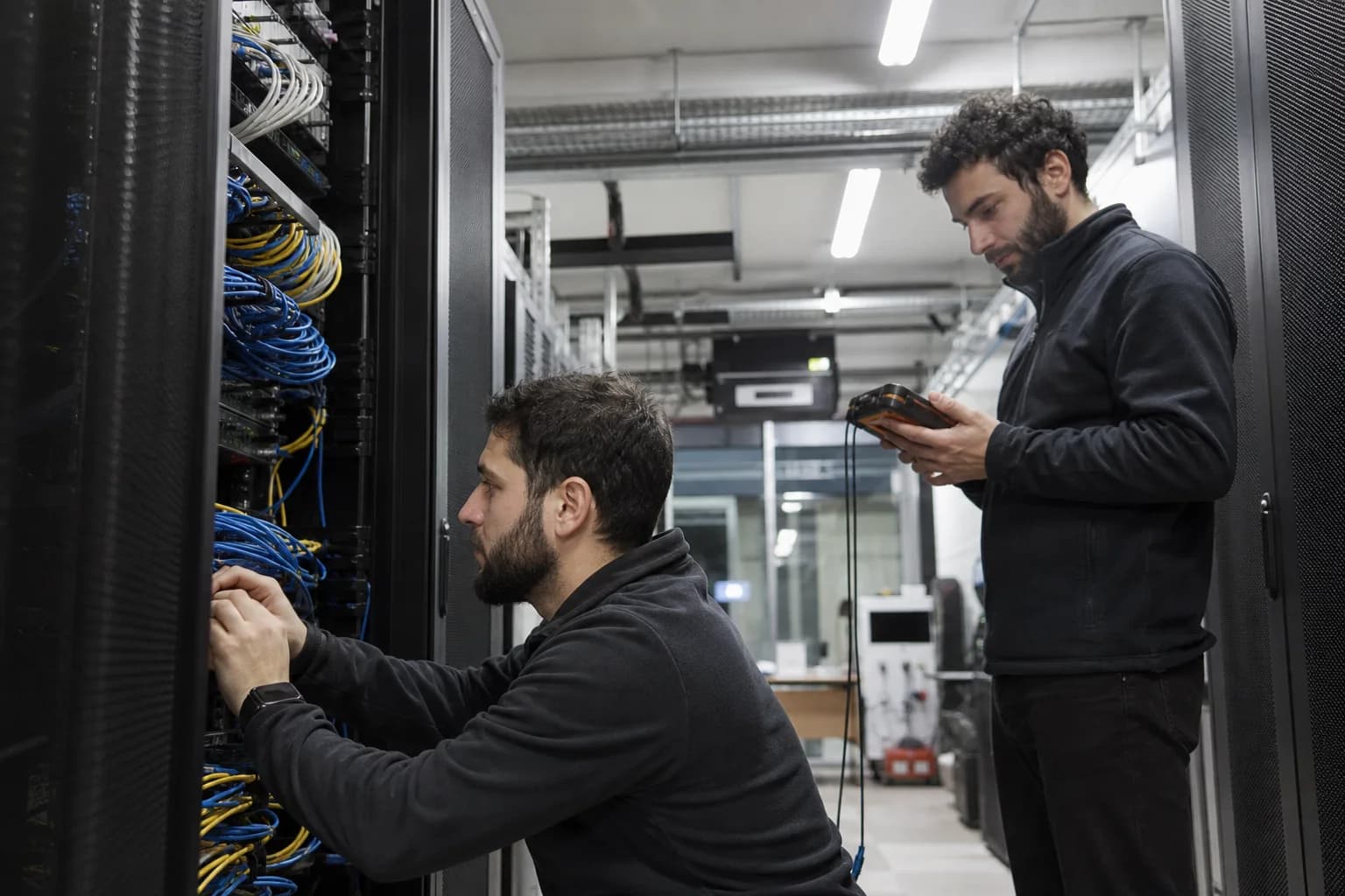Two infrastructure engineers work inside a Tbilisi data centre.